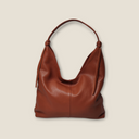 Vista frontale della borsa Ambra in pelle dollaro color ambra; si nota la struttura morbida e i manici larghi studiati per il comfort a spalla.