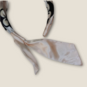 Dettaglio sartoriale dei nastri laterali a coda di rondine del cerchietto Phlegráia, un particolare abbellimento in stoffa che aggiunge movimento all'acconciatura.