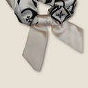 Particolare delle code di rondine in stoffa color champagne dello scrunchie artigianale, un dettaglio ricercato per dare movimento ai capelli.